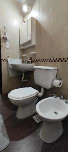 a bathroom with a toilet and a sink in it at Departamento Bienestar Termas in Federación +18 photos