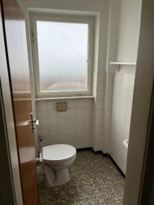 a bathroom with a toilet and a window at Eventus-House in Horb am Neckar