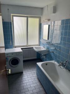 a bathroom with a tub and a sink and a washing machine at Eventus-House in Horb am Neckar