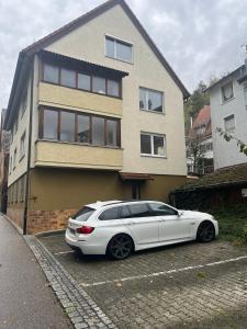 une voiture blanche garée devant une maison dans l'établissement Eventus-House, à Horb am Neckar