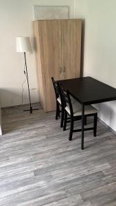 une table noire avec deux chaises et une lampe dans une pièce dans l'établissement Eventus-House, à Horb am Neckar
