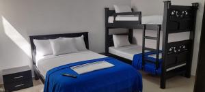 um quarto com 2 beliches e uma cama azul em Hotel La Guajira - Centro Historico em Ríohacha