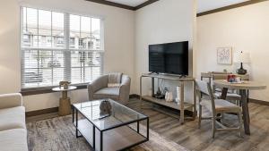 sala de estar con TV, sofá y mesa en Landing Modern Apartment with Amazing Amenities (ID8320X88), en Louisville