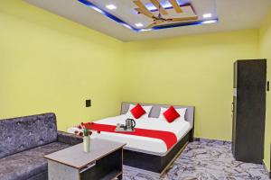 een slaapkamer met een bed en een bank bij Flagship Hotel Jnk in Bilāspur
