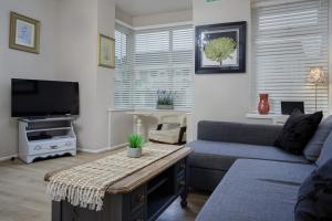 a living room with a couch and a tv at Hornby Apartments in Blackpool