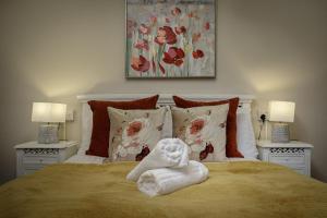 a towel animal sitting on a bed with two lamps at Hornby Apartments in Blackpool +13 photos