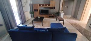 ein Wohnzimmer mit einem blauen Sofa und einem Tisch in der Unterkunft Meteora House with a view in Kalambaka