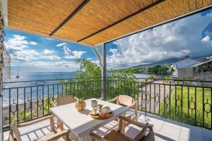a table and chairs on a balcony with a view of the ocean at Villa Alma Da Lua in Saint-Pierre