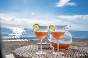 two wine glasses sitting on a table near the beach at Villa Alma Da Lua in Saint-Pierre