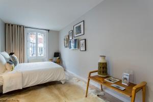 a white bedroom with a bed and a table at Gasparin - Studio - Lyon 2 in Lyon