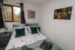 sypialnia z łóżkiem z zielonymi poduszkami w obiekcie Studio 2 w mieście Totnes