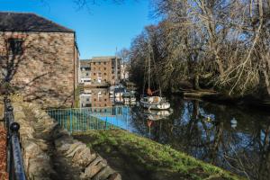 a river with a building and boats in the water at Studio 2 in Totnes