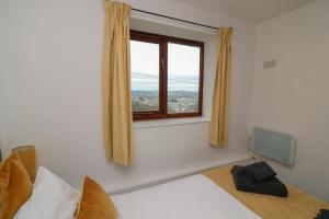 a bedroom with a bed with a window and a television at Studio 1 in Totnes