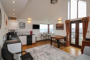 a kitchen and living room with a table and chairs at Studio 1 in Totnes