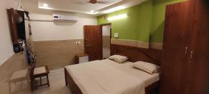een slaapkamer met een bed en een groene muur bij OYO 82374 Hanuman Residence in Erragondapālem