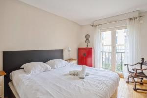 een slaapkamer met een groot wit bed en handdoeken bij Nice house with garden in Versailles - Welkeys in Versailles