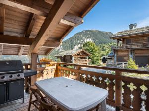 a balcony with a table and a stove at Chalet Courchevel 1550, 6 pièces, 8 personnes - FR-1-562-44 in Courchevel
