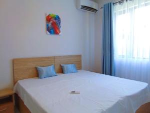 ein Schlafzimmer mit einem großen weißen Bett mit blauen Kissen in der Unterkunft Spacious 3-Bedroom Apartment near Pereybere Beach in Pereybere
