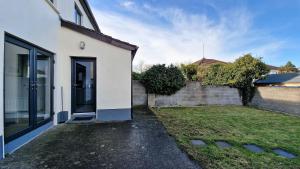 a white house with a fence and a yard at 2 minute walk to LUAS (tram) in Dublin