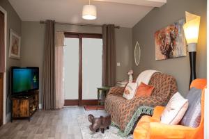 a living room with a couch and a tv at The Veterinary @ Kildare Village in Kildare