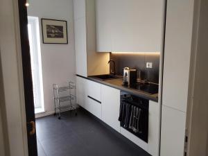 托斯卡尼亞的住宿－LESS IS MORE，小厨房配有白色橱柜和水槽
