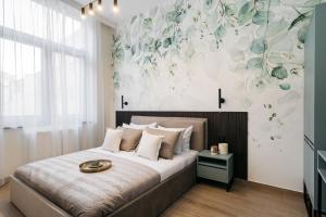 sypialnia z łóżkiem z malowidłem kwiatowym na ścianie w obiekcie MUSE - LoftAffair Collection w Krakowie