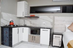 a small kitchen with a sink and a microwave at De Guest @115 in Centurion