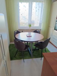 uma mesa e cadeiras num quarto com uma janela em Apartmán Kolářová em Klatovy