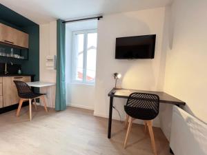 - un salon avec une table, des chaises et une télévision dans l'établissement LA FEUILLERAIE N2-Standingappart-Wifi-Proche ville, à Fontenay-le-Comte