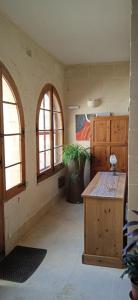 um quarto com duas janelas e uma mesa de madeira em Tas-Suplu Farmhouse em San Lawrenz