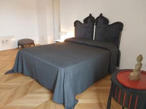 una camera da letto con un letto con una coperta blu e un tavolo di LESS IS MORE a Tuscania