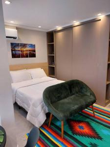 um quarto com uma cama e uma cadeira num tapete em Studio Concept Panamby - Ao Lado do Metrô em São Paulo