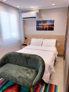 um quarto com uma cama grande e uma cadeira em Studio Concept Panamby - Ao Lado do Metrô em São Paulo