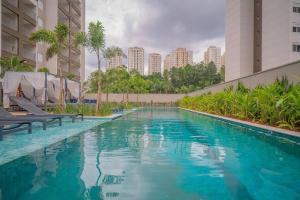 a swimming pool with blue water in a building at Studio Giovanni Gronchi - Ao Lado do Metrô in São Paulo