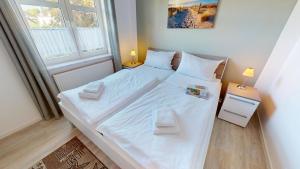 グレーミッツにあるGrüntal-Residenz Haus II App. 4のベッドルーム1室(大型ベッド1台、白いシーツ、枕付)
