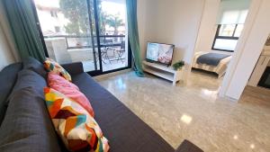 ein Wohnzimmer mit einem Sofa und einem TV in der Unterkunft Cancún Portaventura Familidays in Salou