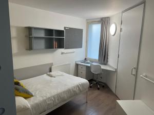a bedroom with a bed and a desk and a window at Cosy Private Ensuites and Studios in the heart of Cheltenham in Cheltenham