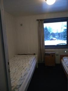 a small bedroom with a bed and a window at Frivoll, 35 minutes walk to town. in Arendal