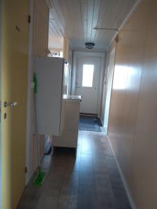 a hallway with a white refrigerator in a room at Frivoll, 35 minutes walk to town. in Arendal