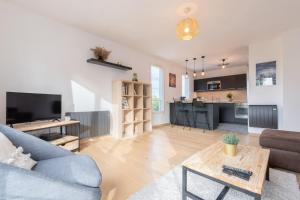 a living room with a couch and a table at Beautiful apartment equipped near train parking in Lille