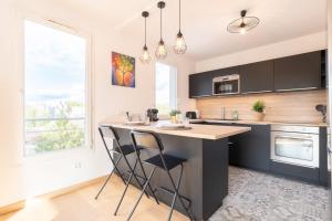 a kitchen with a large island with two bar stools at Beautiful apartment equipped near train parking in Lille