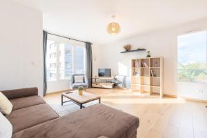 a living room with a couch and a table at Beautiful apartment equipped near train parking in Lille