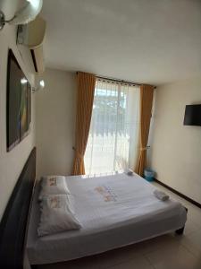 a large bed in a room with a window at ROYALPARK in Venadillo