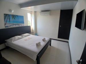 a bedroom with a bed with white sheets and a window at ROYALPARK in Venadillo