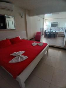 a bedroom with a red bed with two bows on it at ROYALPARK in Venadillo
