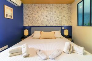 ein Schlafzimmer mit einem Bett mit zwei Paar Hausschuhen in der Unterkunft SELECT'soHOME - Bel appartement rénové idéalement situé au coeur du Lavandou et de ses animations ! - MARINA-5 in Le Lavandou