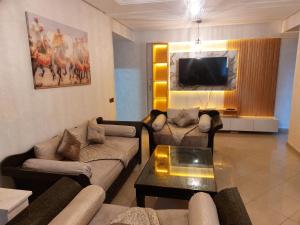 a living room with couches and a flat screen tv at Appartement kenitra mall in Kenitra
