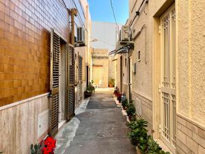 un callejón entre dos edificios con flores a un lado en Casa Vacanze A un Passo dal Volo en Bari