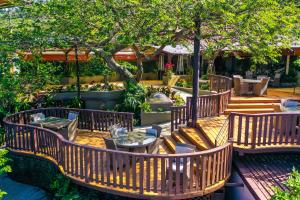 un patio al aire libre con mesas, sillas y árboles en Hotel & Spa Poco a Poco - Costa Rica en Monteverde Costa Rica