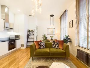 sala de estar con sofá verde y cocina en Be London - Covent Garden Apartments en Londres